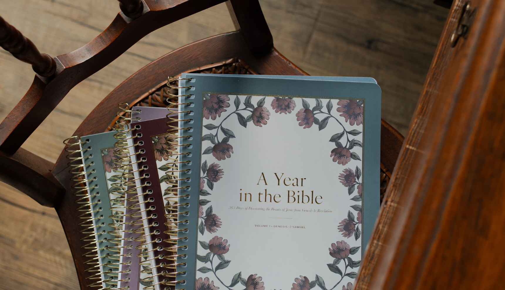 A stack of A Year in the Bible Spiral Studies on a wooden chair