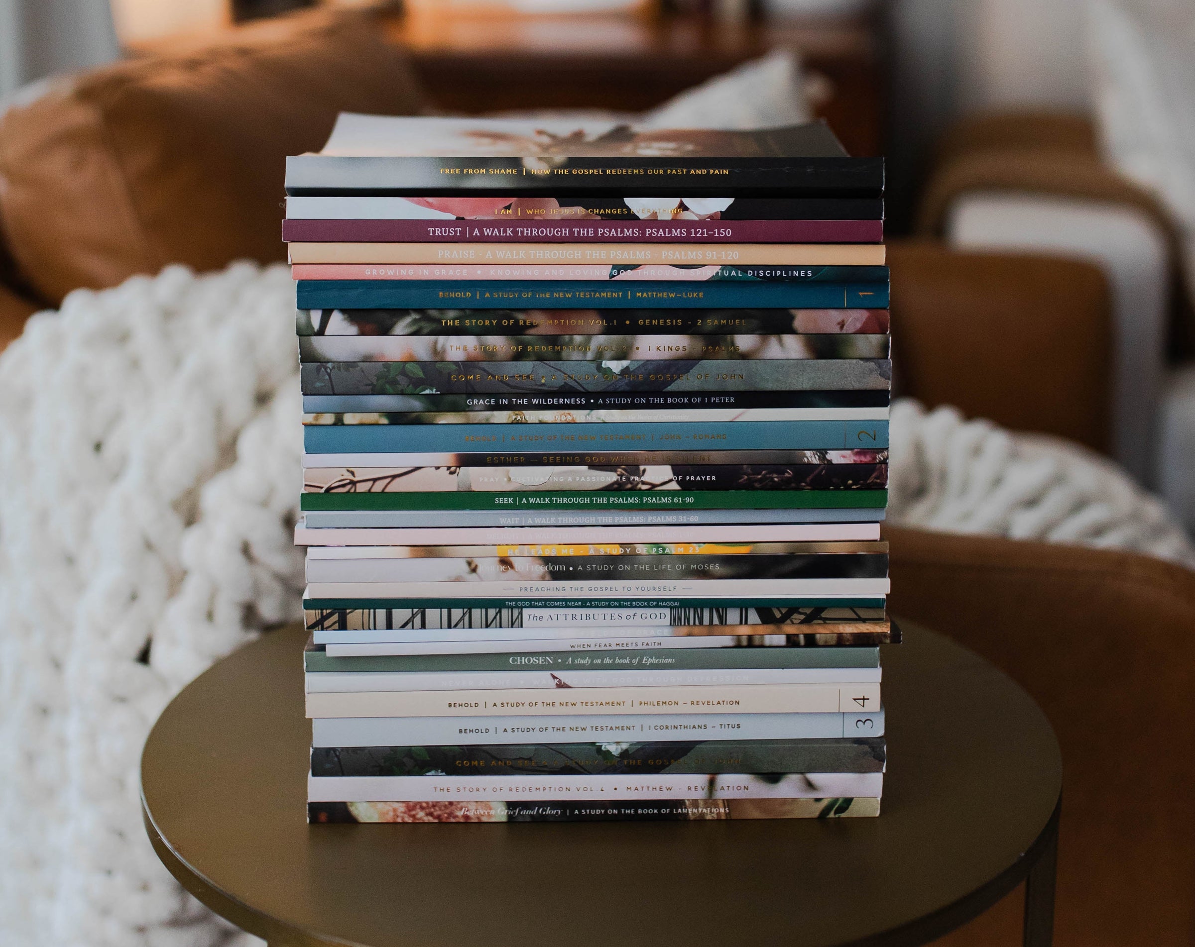 Stack of Bible Studies on a brass table.