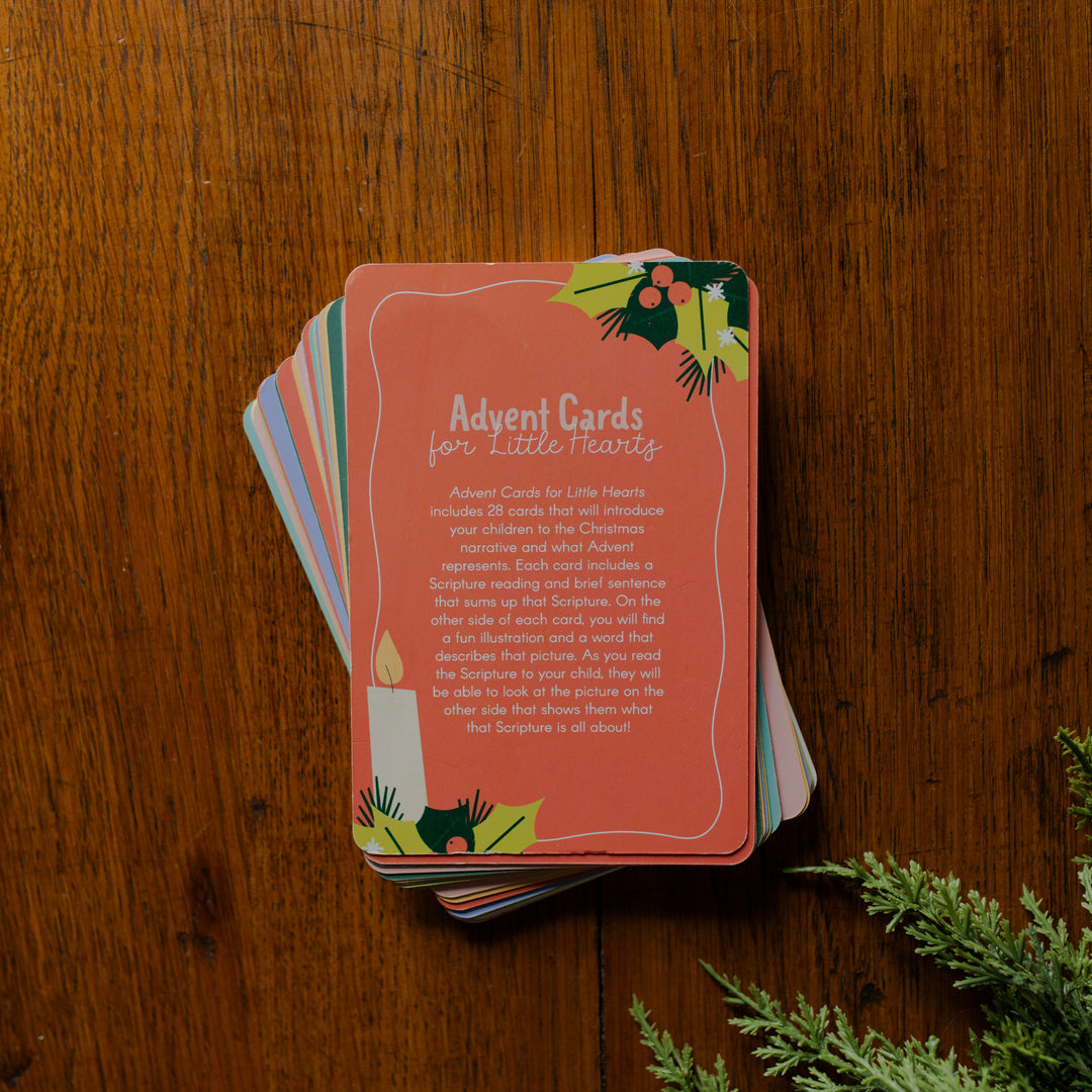 A Stack of Advent for Little Hearts on a wooden table next to some greenery