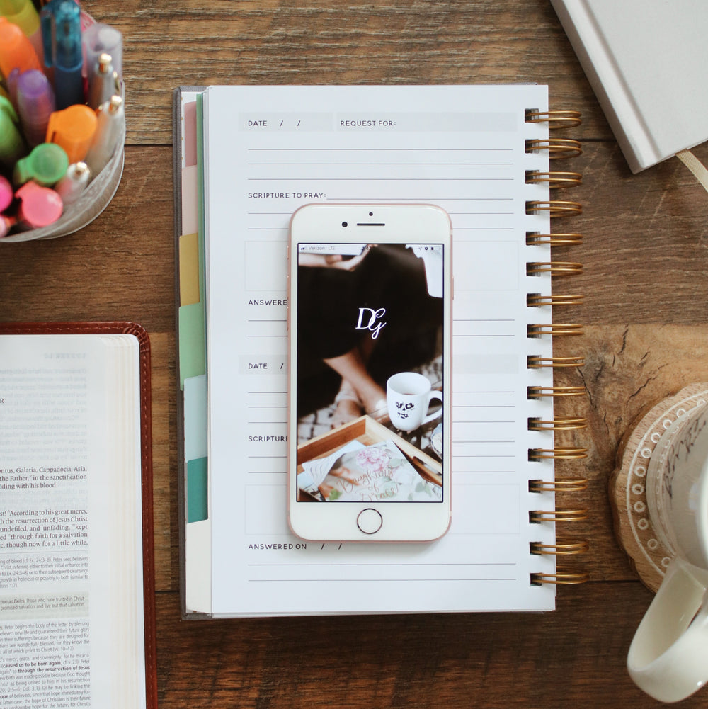 Phone with the Daily Grace app sitting on a planner