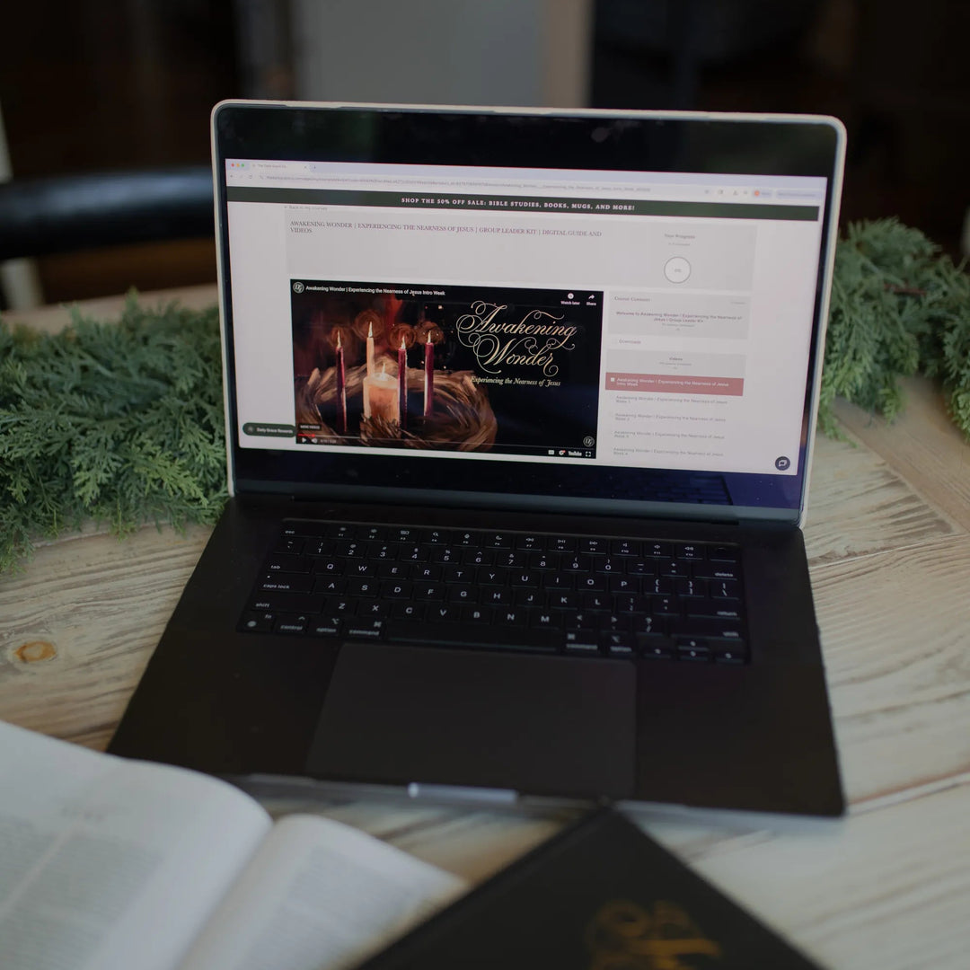 Awakening Wonder Group Leader Guide loaded on a laptop on a light wooden table next to some greenery