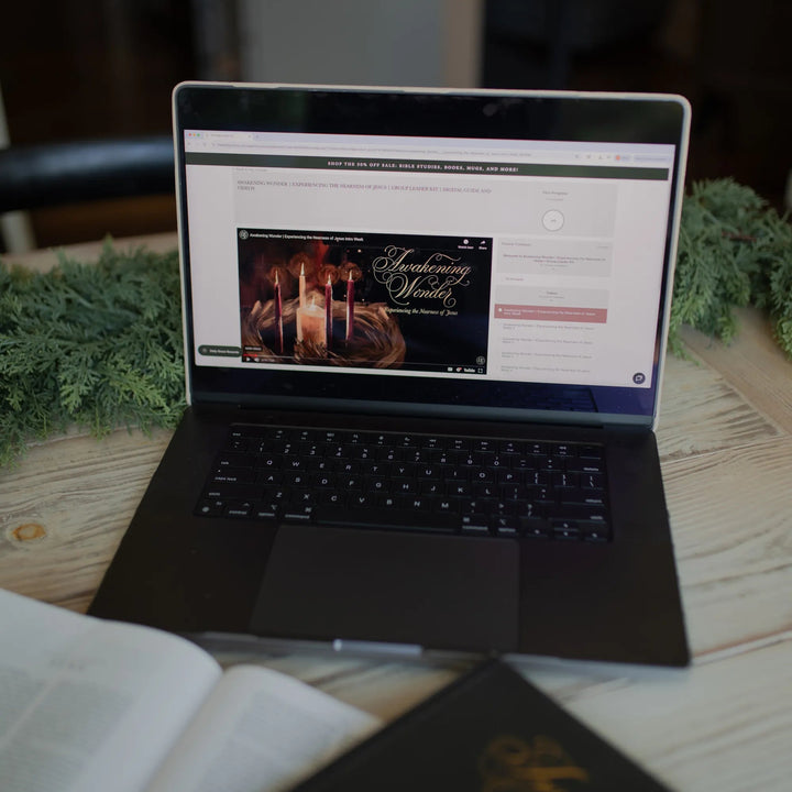 Awakening Wonder Group Leader Guide loaded on a laptop on a light wooden table next to some greenery