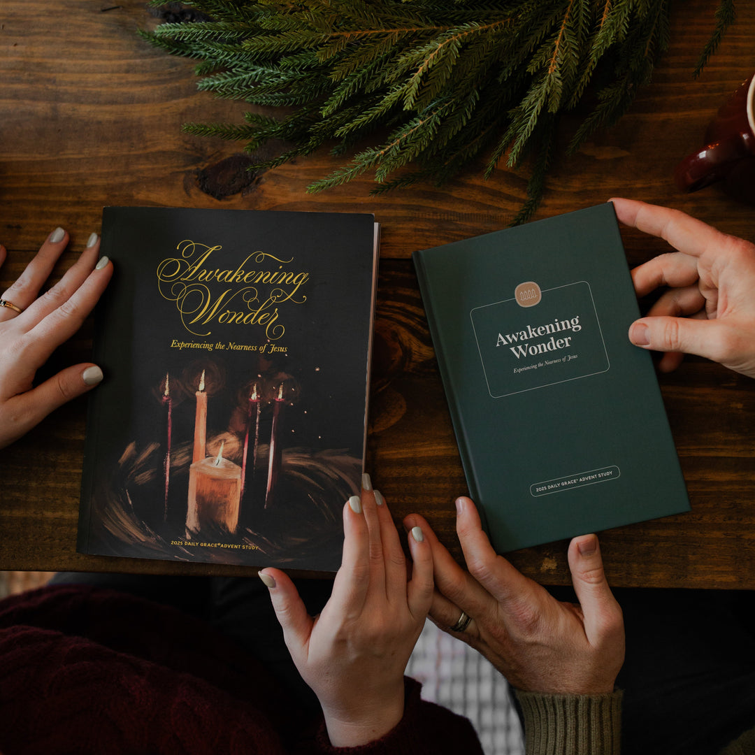 The Awakening Wonder Woman and Mens study side by side on a wooden table with some greenery nearby