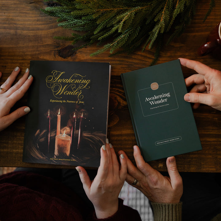 The Awakening Wonder Woman and Mens study side by side on a wooden table with some greenery nearby