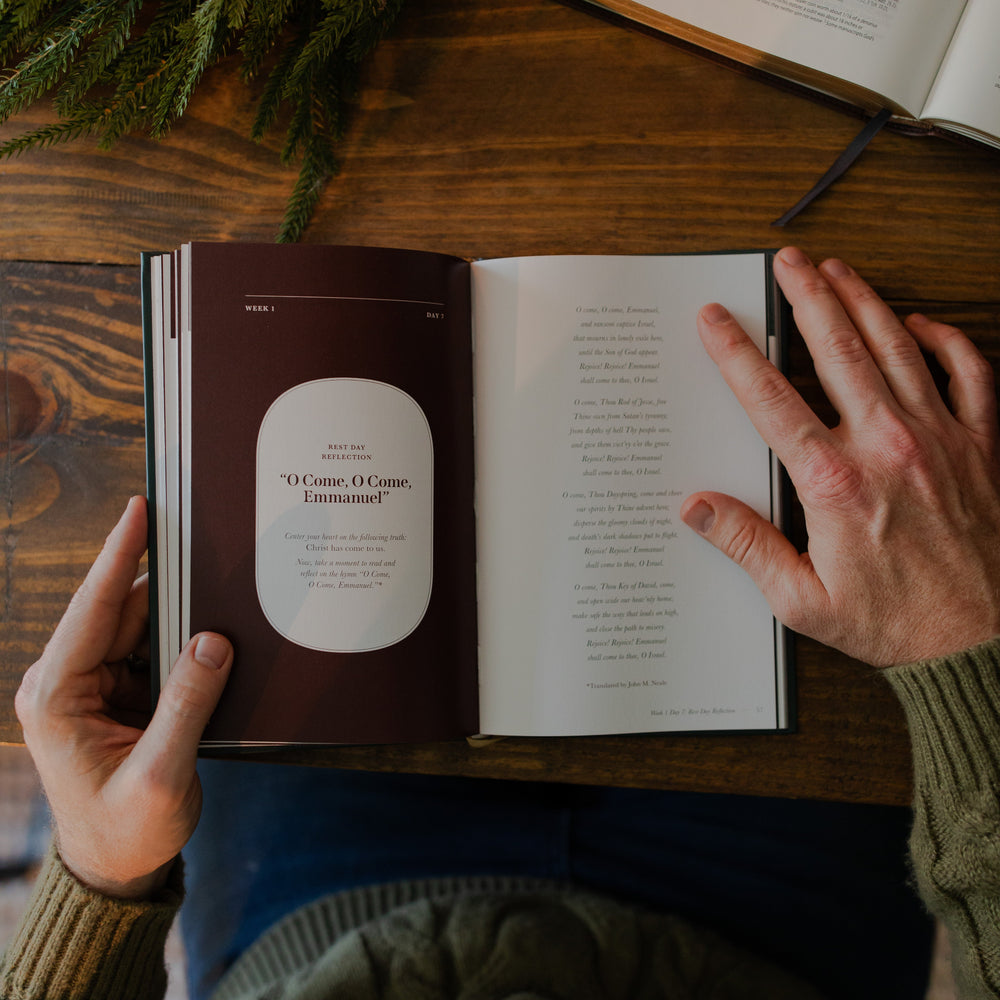 A man's hands holding the Awakening Wonder study open to the Week 1 Day 2 reflection page