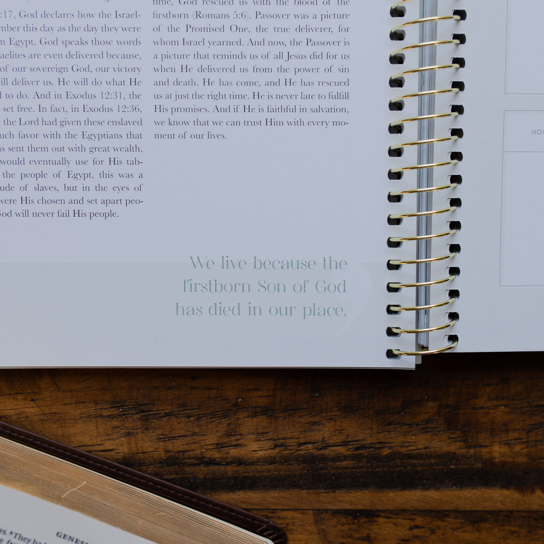 Eden to Eternity Volume 1 spiral opened to a devotional quote up close to the corner of the page on a wooden table