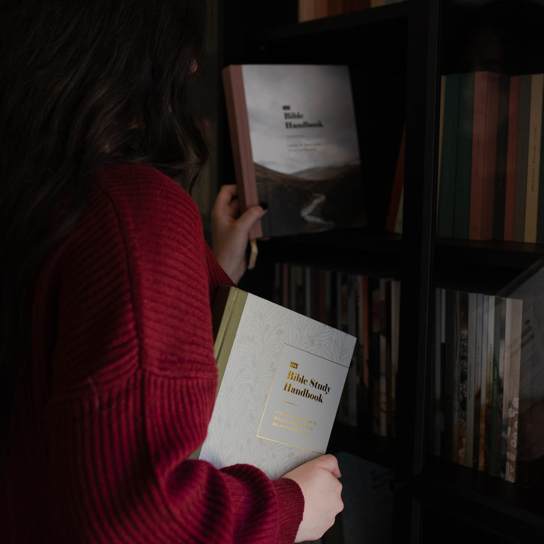 Woman holding The Bible Handbook and The Bible Study Handbook, Christian resources