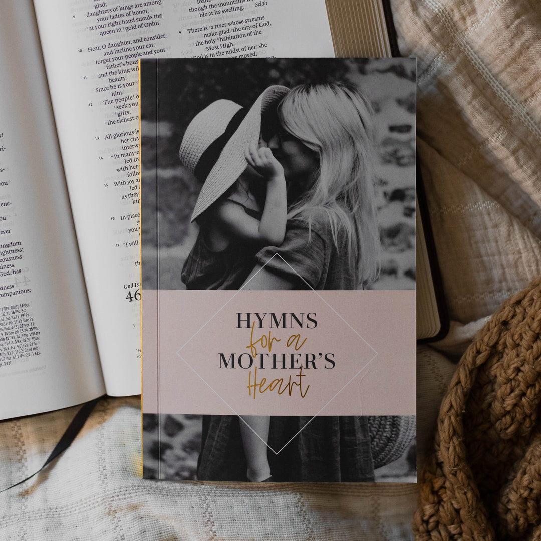 Hymns for a mother's heart book on top of a Bible