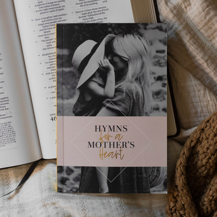 Hymns for a mother's heart book on top of a Bible