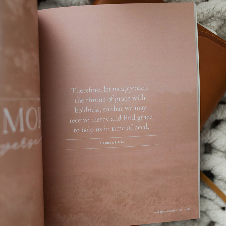 It Is Well Study opened to page 83 memory verse; The Study is laying on a leather book and a white knitted blanket