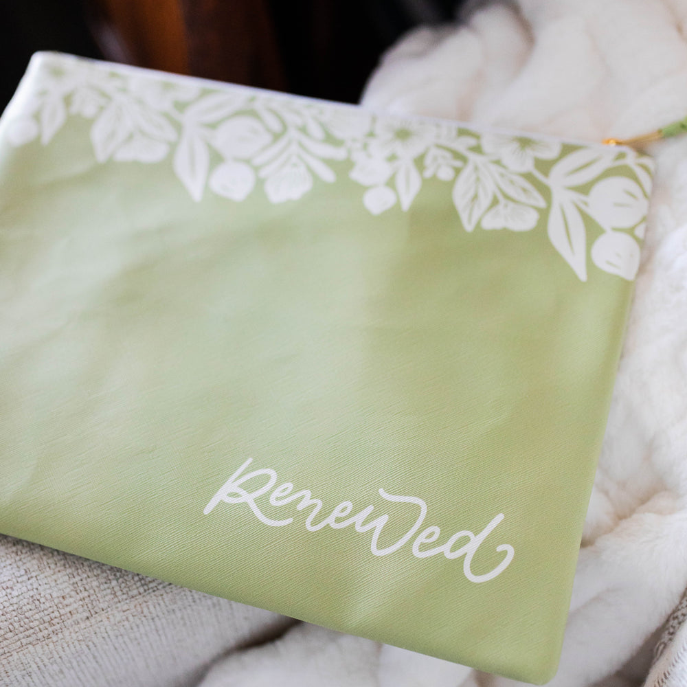 Green renewed pouch on a white couch.