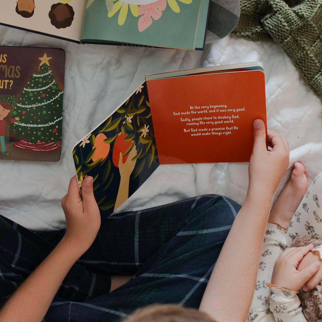 Kids in pajamas reading The Promised One Christmas board book for kids