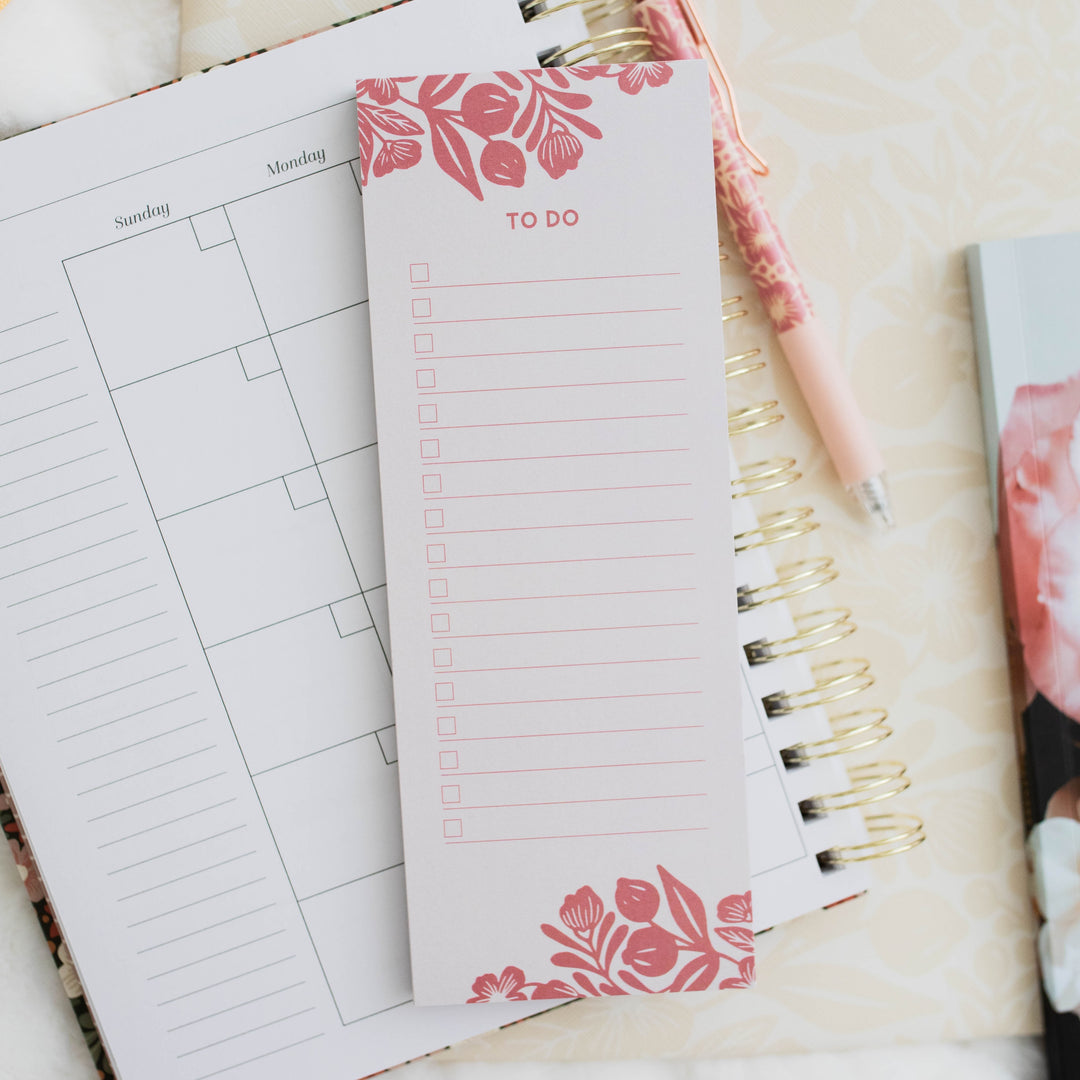 photo of notepad on top of planner next to pen