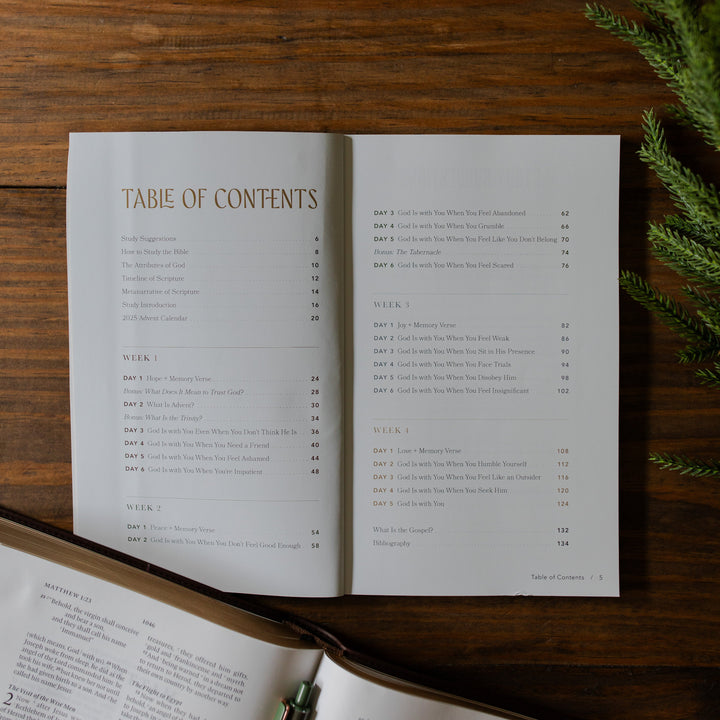 With you Always Teen Advent Study opened to the Table of Contents on a wooden table next to some greenery