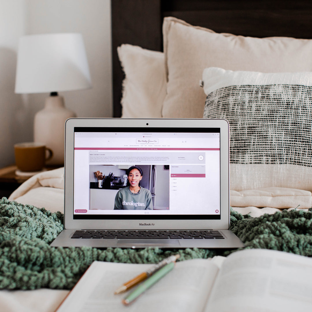 computer with digital bible course and bible on bed
