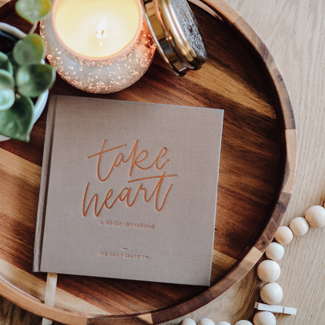 Devotional book on table next to candle
