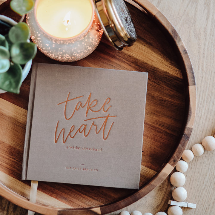 Devotional book on table next to candle