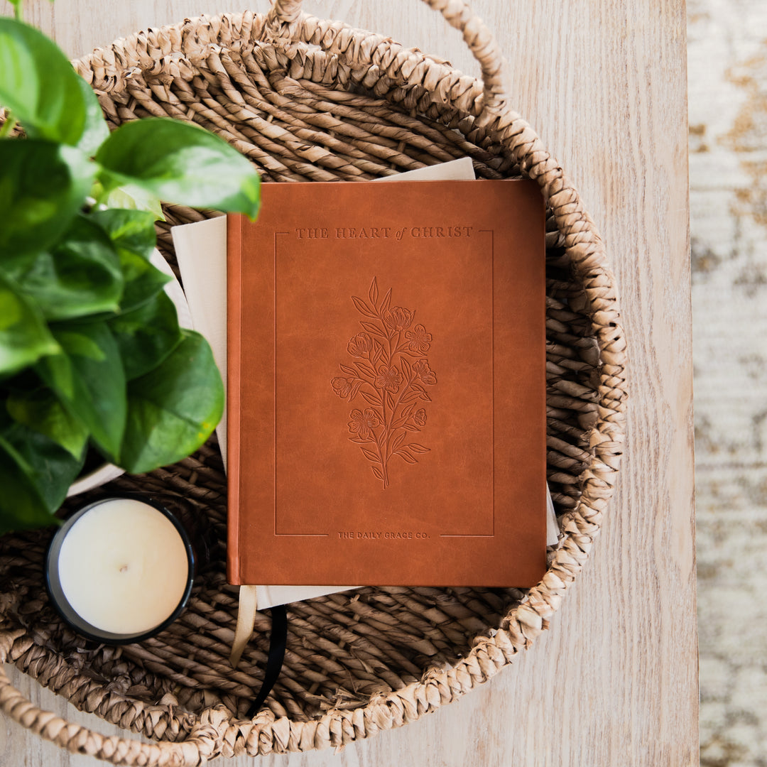 devotional next to candle on tray