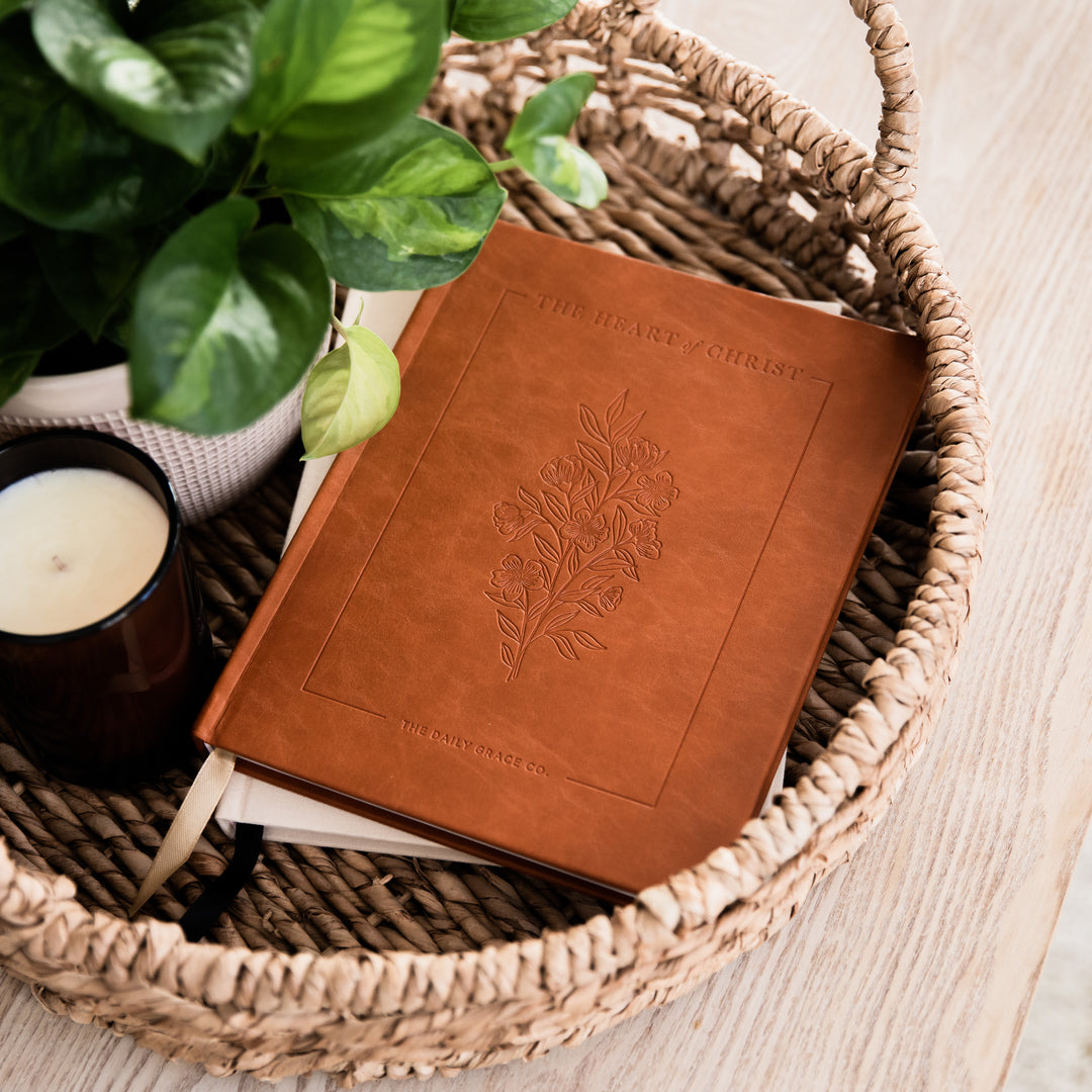 devotional closed on tray next to candle and plant