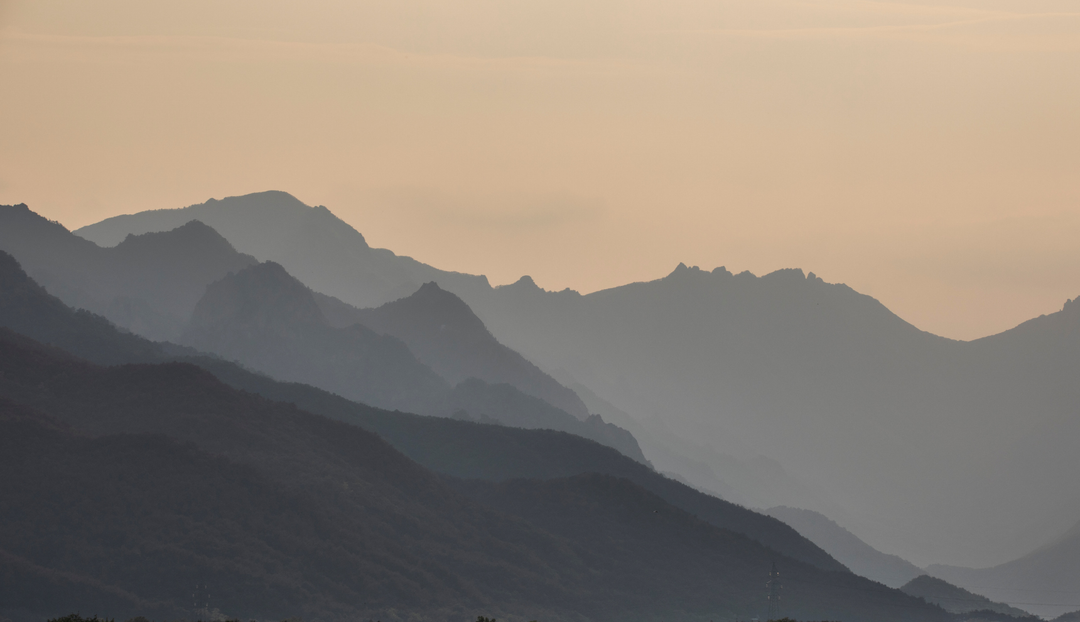 A faded background of multiple mountain ranges