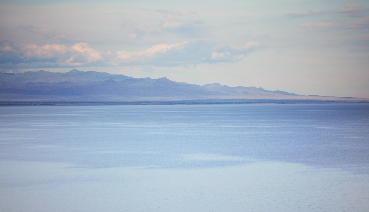 A calm sea overlooking a distant mountain range