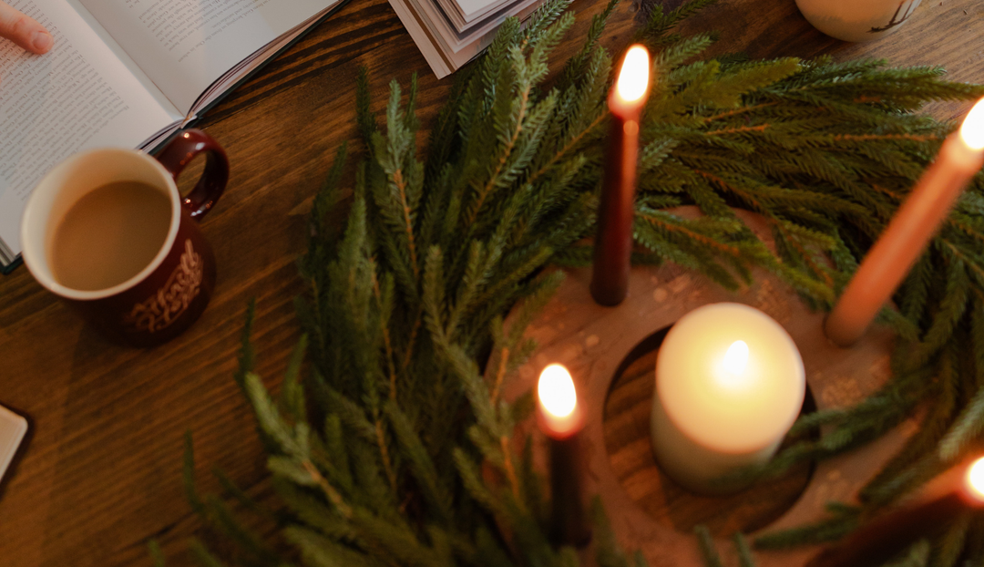 Advent candle ring with lit candles in it surrounded by a green wreath