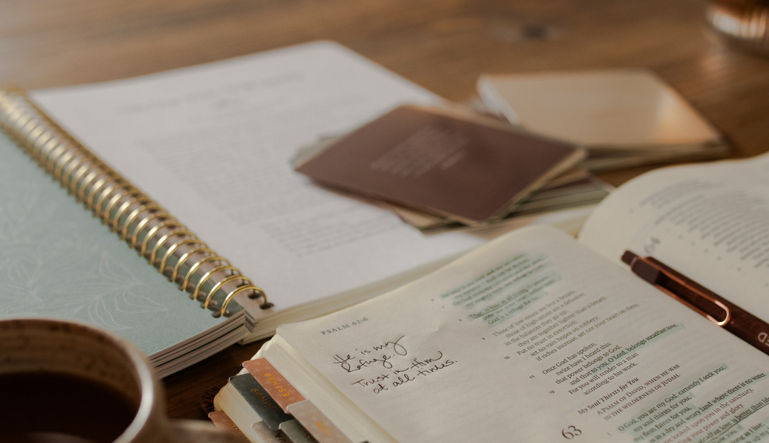 An open bible and an open journal with various verse cards on it
