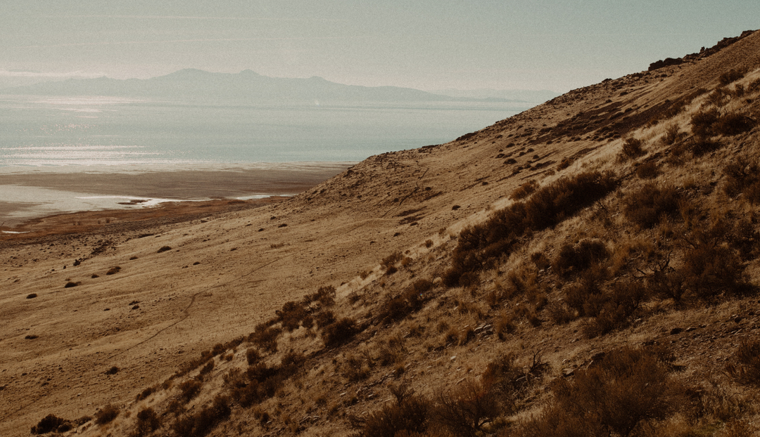 Sandy mountain side to an overlooking distant mountain