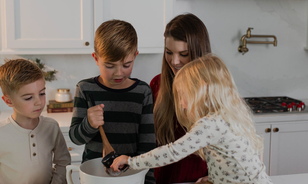 Woman helping her children cook