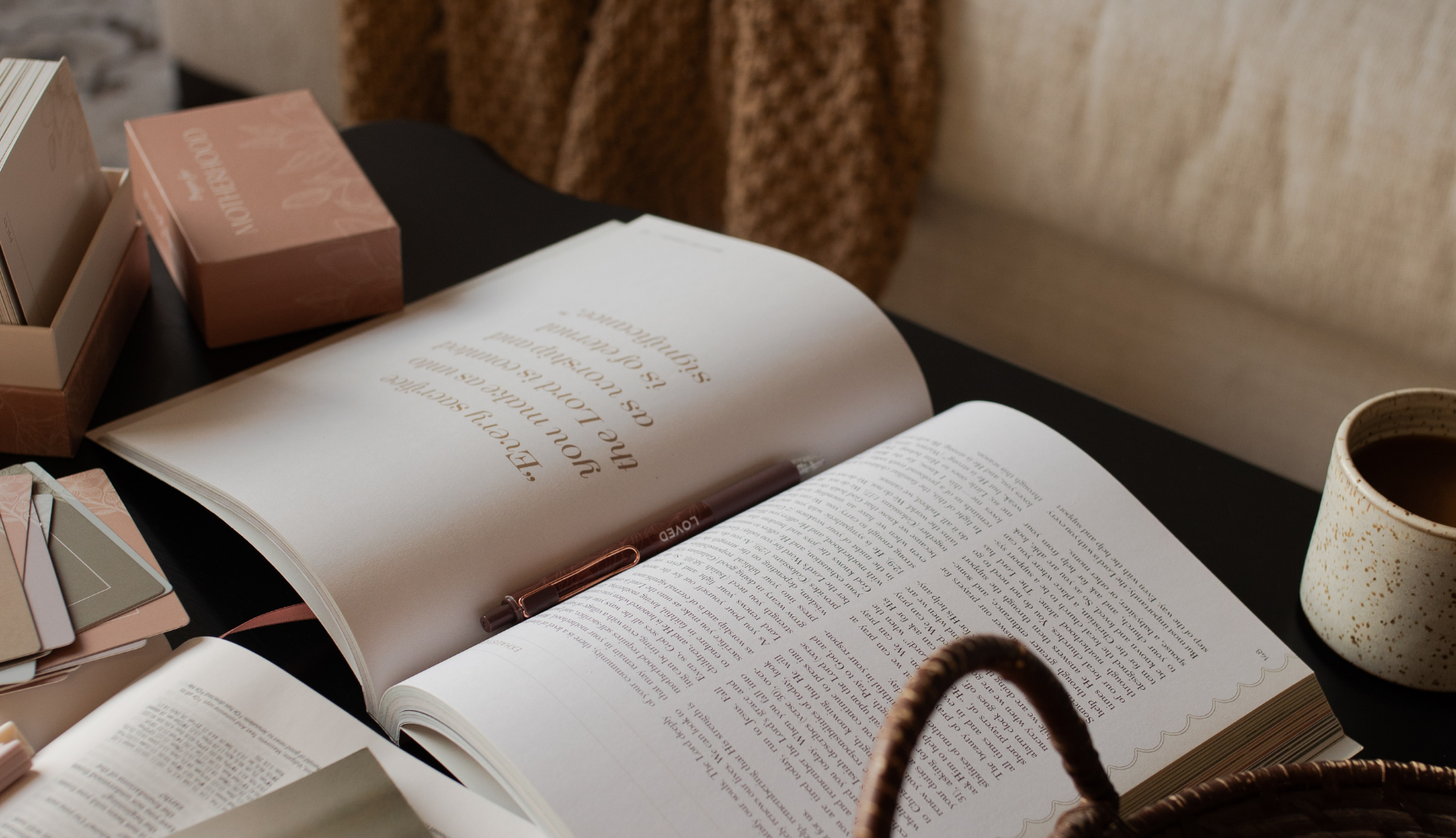 An open study with a pen in the crease of the study with a nearby coffee