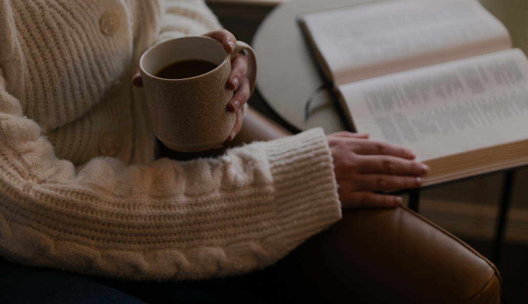 A woman with an open bible and a cup of coffee