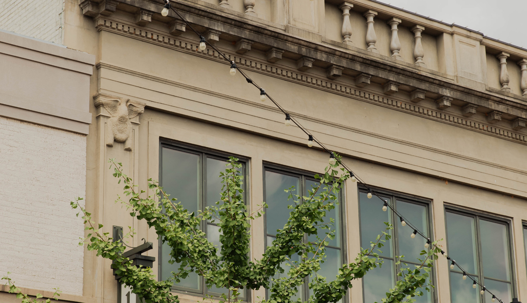 The side of a building with string lights going to the roof