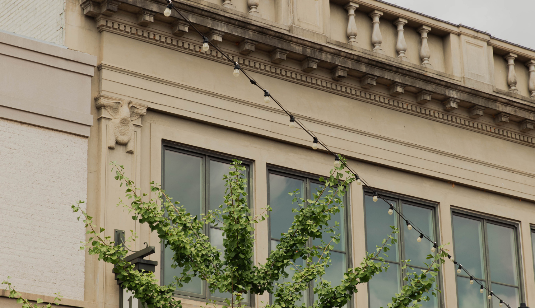 The side of a building with string lights going to the roof