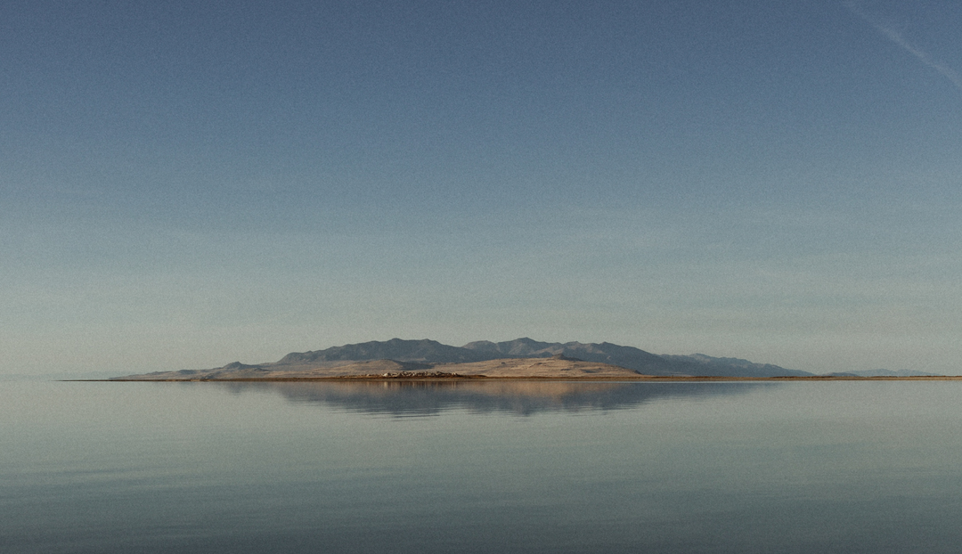 An Island in the distance with water and a clear sky surrounding it