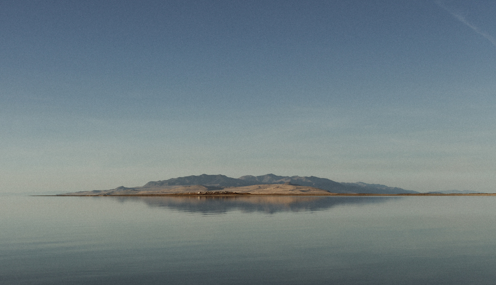 An Island in the distance with water and a clear sky surrounding it