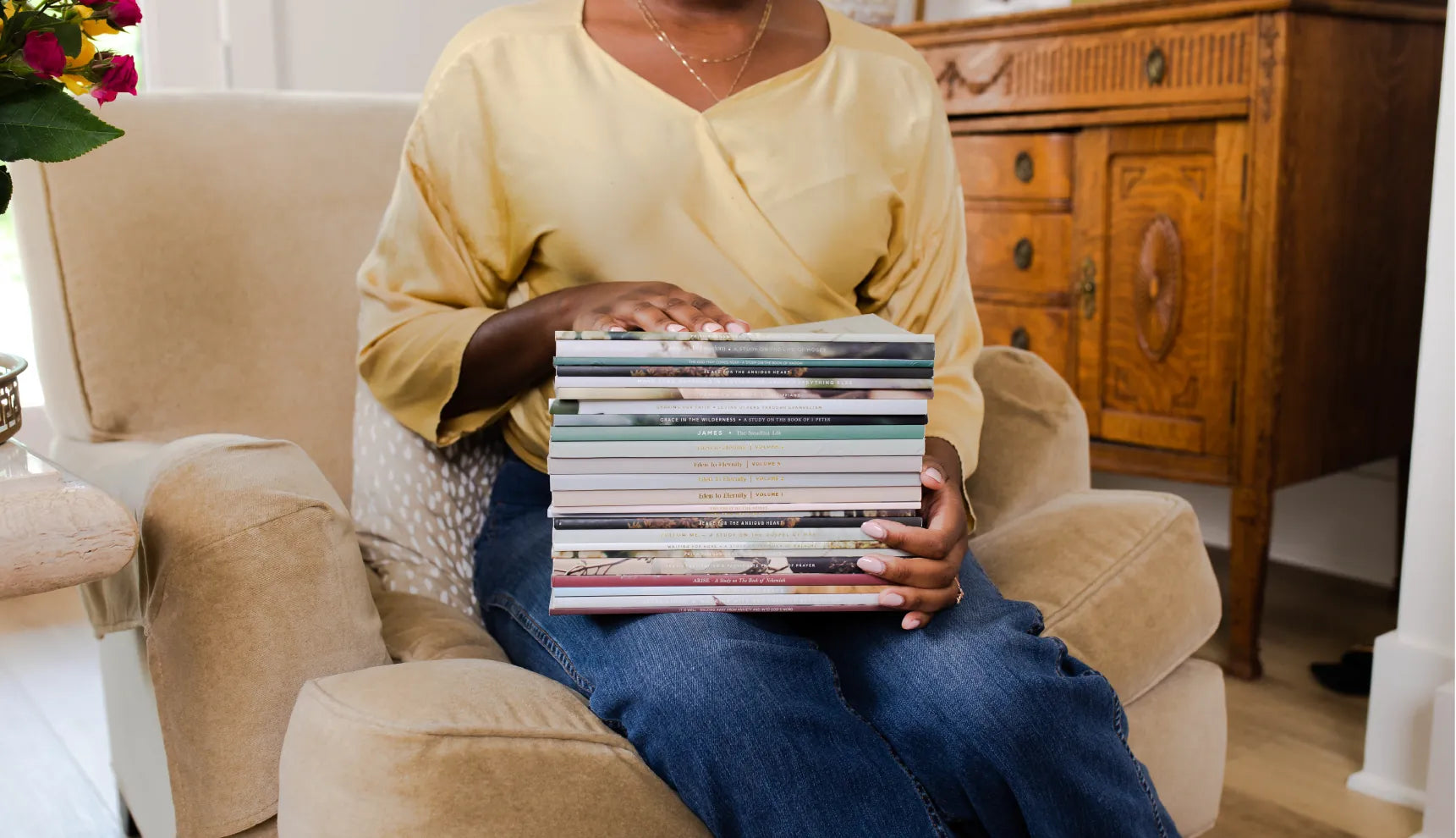 A woman holding a stack of Daily Grace Bible Studies on her lap