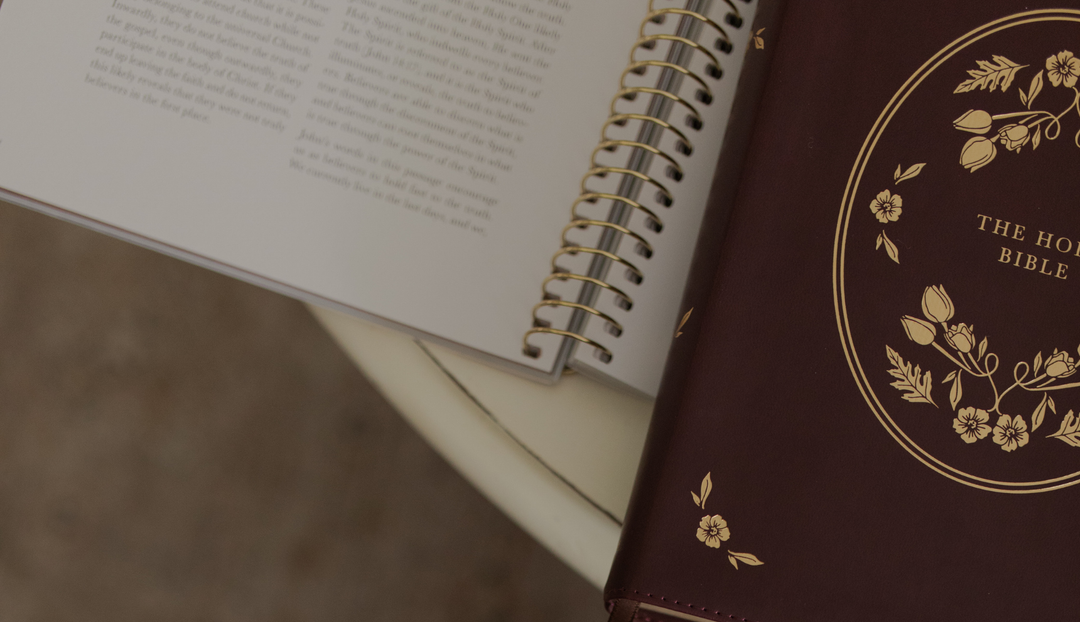 A closed bible on a open spiral on a white table