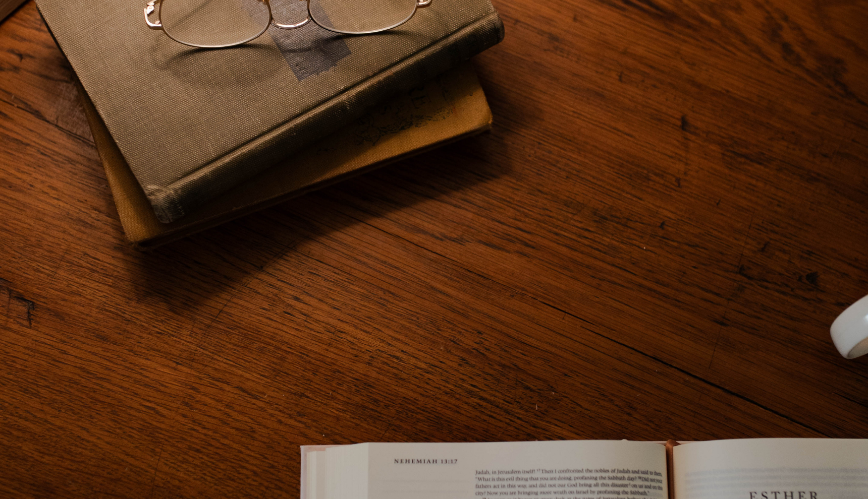 Glasses on a stack of bibles on a wooden table