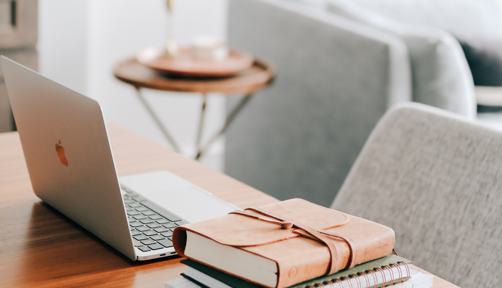 A laptop and a closed bible on a table 