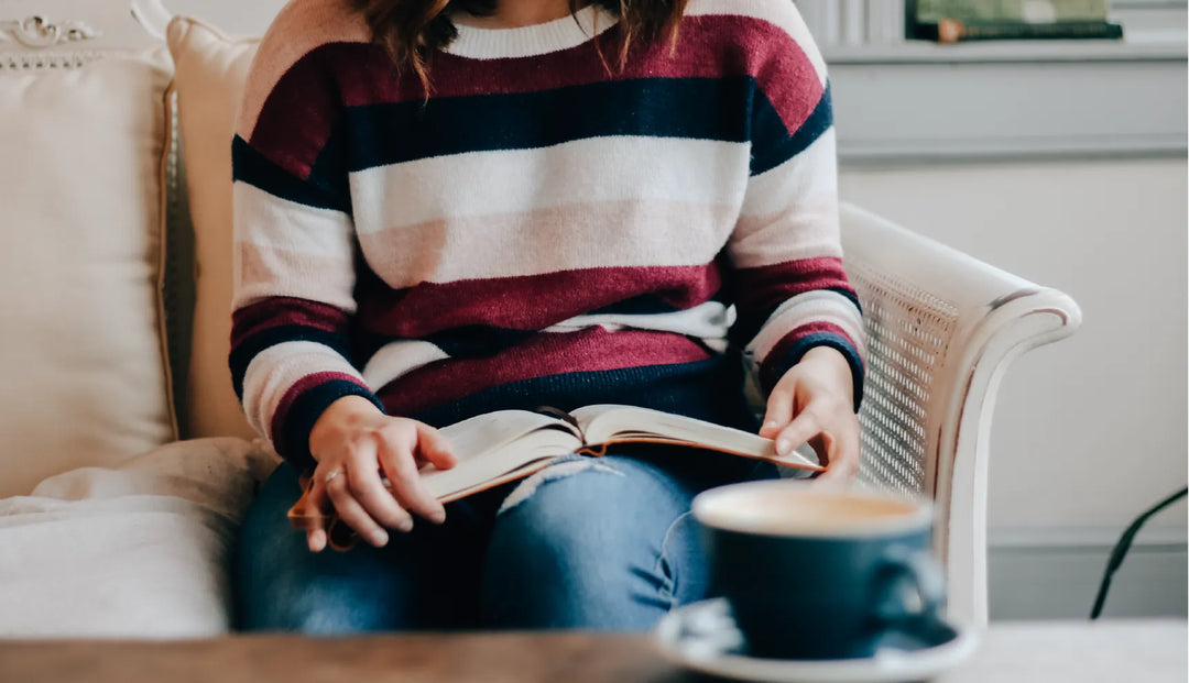 A woman with a striped sweater with a bible opened on her lap