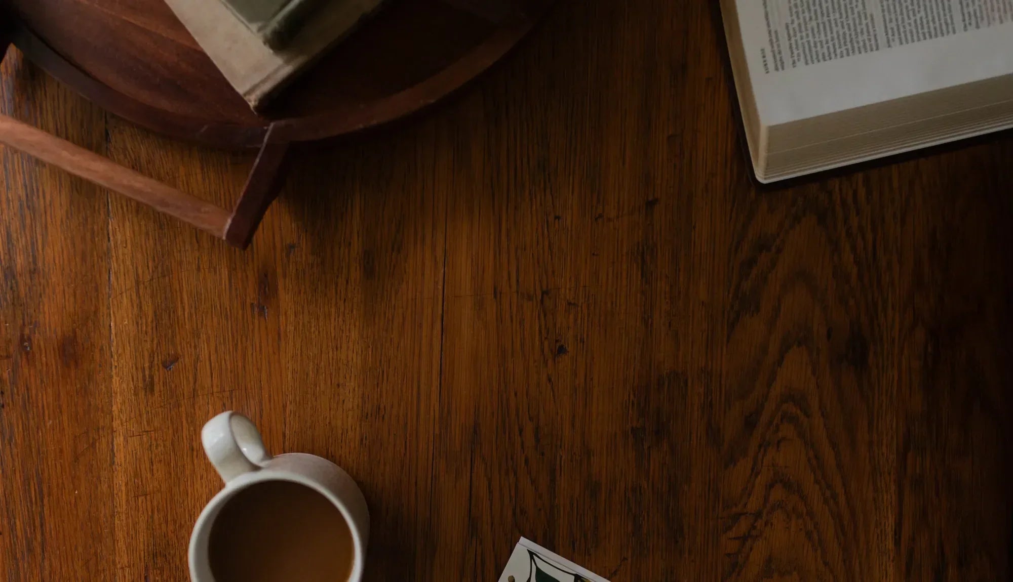 Wooden desk with a coffee cup and an open bible in the corner