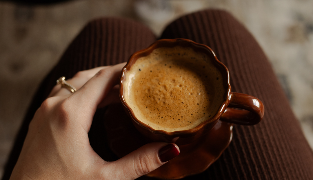 A woman's hand holding a cup of coffee