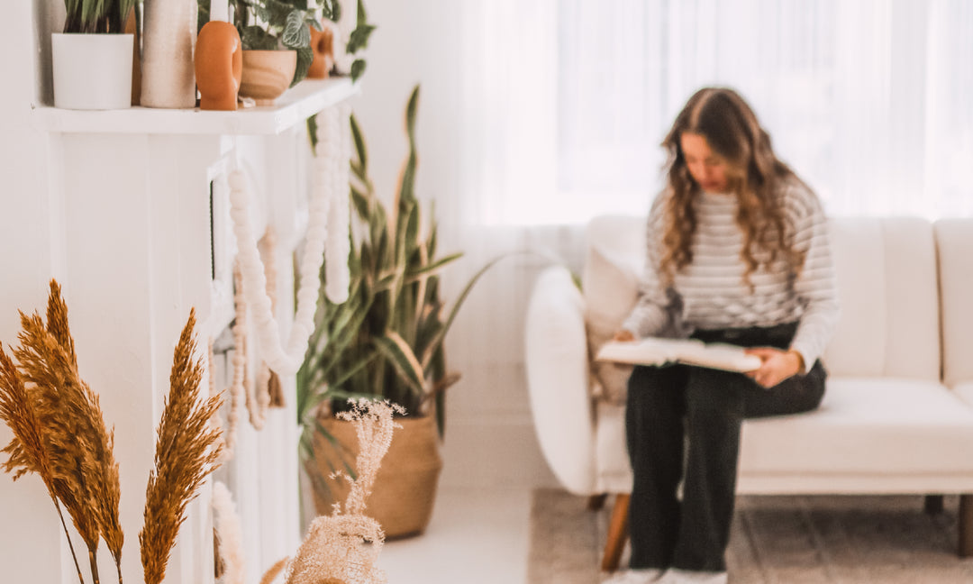 Women sitting on the couch reading her Bible 