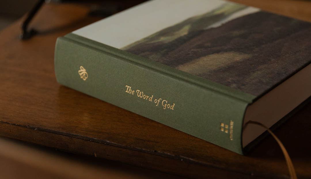 A bible with the text saying The Word of God on the spine on a wooden table