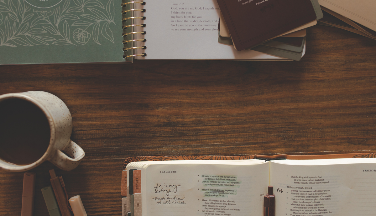 An open Daily Grace study near an open Bible and a Coffee cup on a wooden table