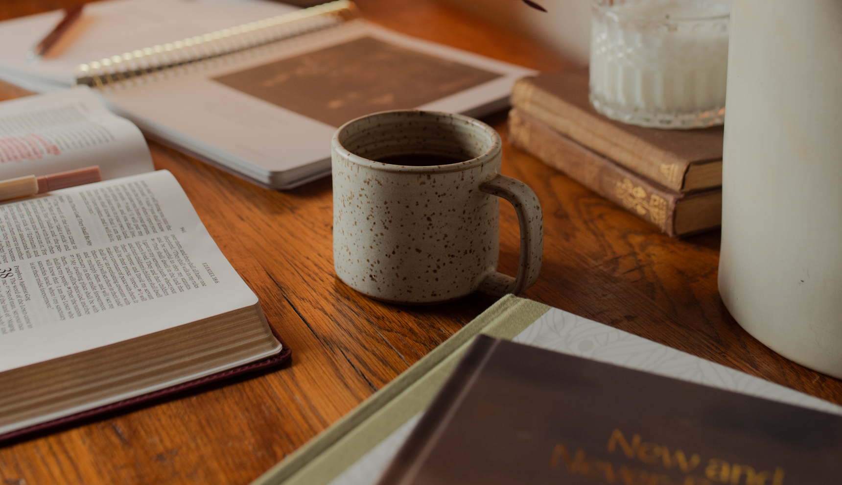 A coffee cup on a wooden table near multiple studies