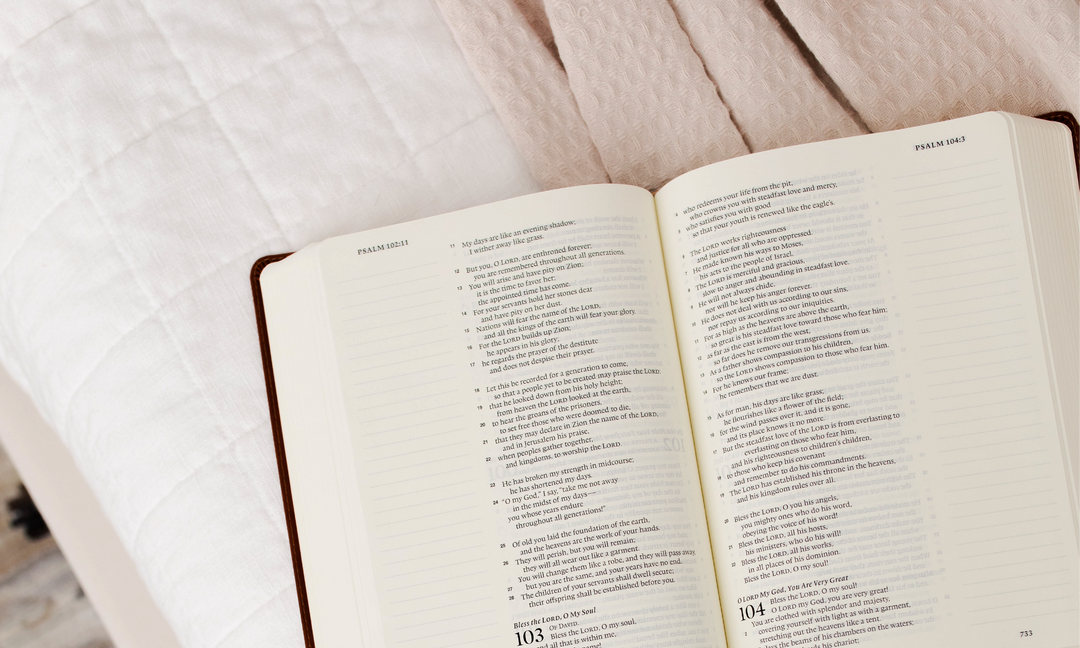 Open Bible on top of a cream colored blanket