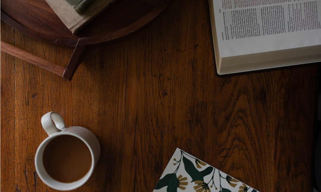 coffee with a Bible study and a Bible on a brown wooden table