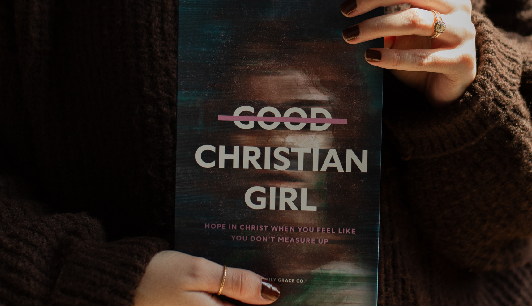 A woman holding up the Good Christian Girl book cover