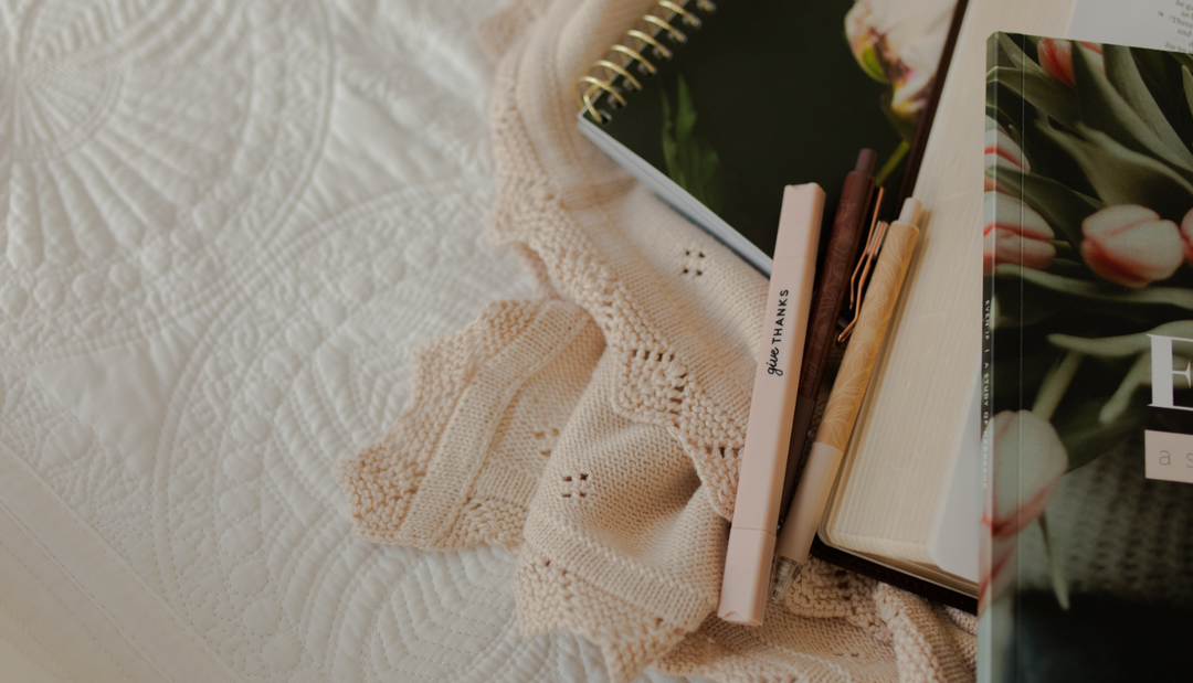 Multiple Daily Grace studies and pens on a white blanket